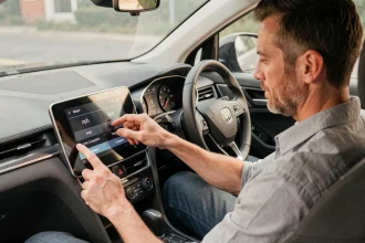Conducteur ajustant les réglages mph kph sur l'écran tactile central d'une voiture moderne